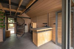 een keuken met een wenteltrap in een houten huis bij Mila Villa in Ngingas