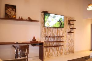 a living room with a tv on a wall at Villa Prana Trancoso - Vista mar in Trancoso