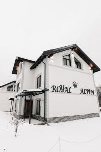 un edificio bianco con un cartello che recita "royal african" di Royal Alpin Crown a Cavnic