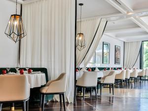 een eetkamer met witte tafels en stoelen bij STORY Rabat in Rabat