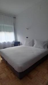 a large white bed in a room with a window at Lavanda Termas de São Pedro do Sul in Termas de Sao Pedro do Sul