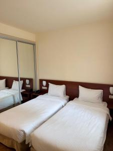two beds in a hotel room with white sheets at Park Resort Aghveran in Aghveran +69 photos