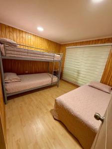 a bedroom with two bunk beds and a window at Home Quillon in Quillón +3 photos