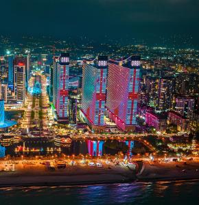 une vue d'une ville la nuit avec des lumières dans l'établissement Panorama Batumi Towers, à Batoumi
