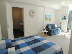 een slaapkamer met een bed en een klok aan de muur bij Stunning apartment in Schoorl, North Hollandâ you can bike to the beach in Schoorl