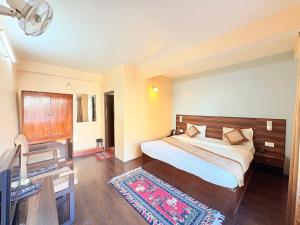 una camera da letto con un letto, una scrivania e una televisione di The OAK Ridge Resort a Gangtok