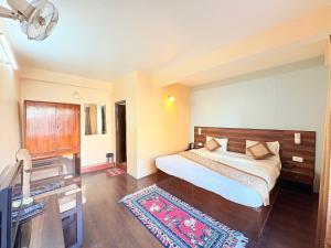 una camera da letto con un letto, una scrivania e una televisione di The OAK Ridge Resort a Gangtok