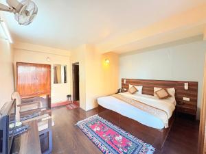 una camera da letto con un letto, una scrivania e una televisione di The OAK Ridge Resort a Gangtok