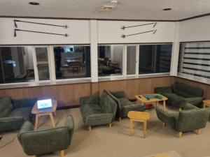 a living room with couches and tables and windows at Nona Madarao in Madarao Kogen +60 photos