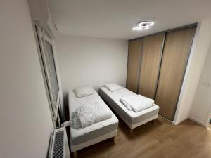 ein kleines Zimmer mit zwei Betten und einem Fenster in der Unterkunft Escapade à Sainte-Cécile 2 chambres, balcon, plage à 50m in Camiers