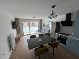 eine Küche und ein Wohnzimmer mit Tisch und Stühlen in der Unterkunft Escapade à Sainte-Cécile 2 chambres, balcon, plage à 50m in Camiers