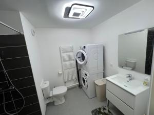 ein Badezimmer mit Waschmaschine und Waschbecken in der Unterkunft Escapade à Sainte-Cécile 2 chambres, balcon, plage à 50m in Camiers
