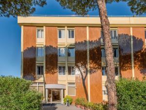 een kantoorgebouw met een boom ervoor bij B&B HOTEL Calenzano First in Calenzano