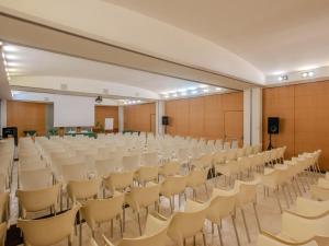 een lege hal met rijen stoelen en een podium bij B&B HOTEL Calenzano First in Calenzano