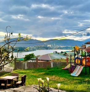 un parco giochi con tavolo da picnic e vista sull'acqua di Queens Lake Cabin a Nuwara Eliya