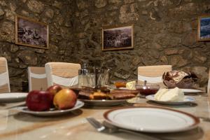 - une table avec des assiettes de nourriture et des fruits dans l'établissement Aspet B&B in Tatev, à Tatev