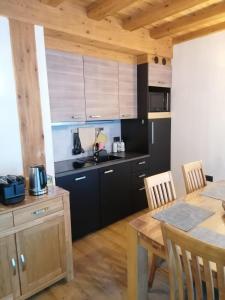 een keuken met zwarte kasten en een houten tafel bij Chalet Noemi in Livigno