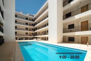 ein Schwimmbad vor einem Gebäude in der Unterkunft Downtown apartment - Terrace, garage and pool in Olhão