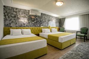 a hotel room with two beds and a couch at Hotel Pera Capitol - Taksim & İstiklal in Istanbul