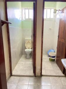 a bathroom with a toilet and a sink at Karmo Suites in Mombasa