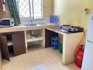 a kitchen with a sink and a stove in it at Karmo Suites in Mombasa