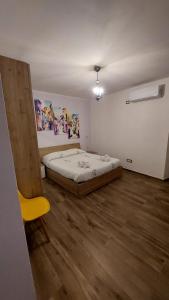 une chambre avec un lit et une chaise jaune dans l'établissement Casa Zia Maria 6 posti Monterosso Coast to Coast, à Monterosso Calabro