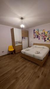 - une chambre avec un grand lit et une chaise jaune dans l'établissement Casa Zia Maria 6 posti Monterosso Coast to Coast, à Monterosso Calabro