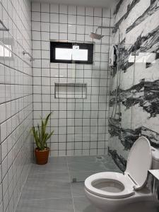 a bathroom with a toilet and a tiled wall at Pinky Bungalows Resort & Villa in Ko Lanta +32 photos
