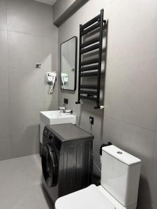 a bathroom with a toilet and a sink and a washing machine at 10 minutes from skiing in Bakuriani +15 photos