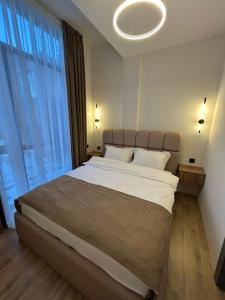 a bedroom with a large bed with a large window at 10 minutes from skiing in Bakuriani