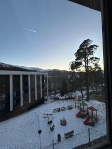a view from a window of a playground in the snow at 10 minutes from skiing in Bakuriani