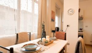 a dining room with a table and a clock on the wall at Fiume 34 - bilocale luminoso e moderno a Sondrio in Sondrio