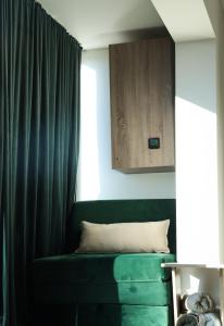 a green couch in a room with a window at Pine apartment Vlašić in Vlasic