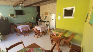une chambre avec deux tables et des chaises ainsi qu'une cuisine dans l'établissement Suítes Cantinho do Sossego Ubatuba, à Ubatuba
