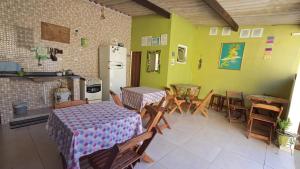 une chambre avec deux tables et des chaises ainsi qu'une cuisine dans l'établissement Suítes Cantinho do Sossego Ubatuba, à Ubatuba
