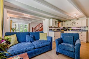 een woonkamer met een blauwe bank en twee stoelen bij 2 Bed in Advent oc-s6025 in Camelford