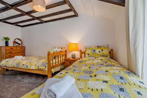 een slaapkamer met 2 aparte bedden en een nachtkastje bij 2 Bed in Advent oc-s6025 in Camelford