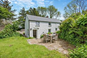 een wit huisje met een tafel en stoelen in de tuin bij 2 Bed in Advent oc-s6025 in Camelford +17 foto's