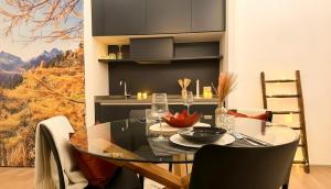 a dining room with a glass table and chairs at Dusdei 4 - monolocale nel centro di Sondrio in Sondrio