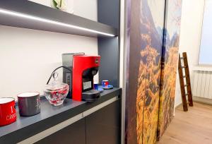 a red coffee maker sitting on a counter at Dusdei 4 - monolocale nel centro di Sondrio in Sondrio