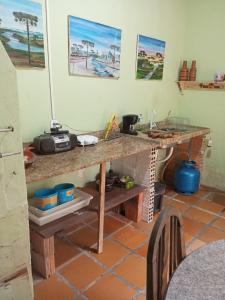 a kitchen with a table with a counter top at Kitnet in Itapema