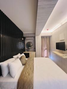 ein Schlafzimmer mit einem großen weißen Bett und einem Fernseher in der Unterkunft Zebra Hotel Buca in Izmir