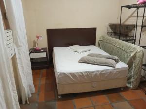 a small bedroom with a bed and a chair at Kitnet in Itapema
