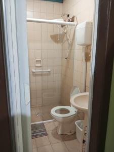 a bathroom with a toilet and a sink at Kitnet in Itapema