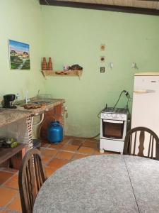 a kitchen with a refrigerator and a table and a stove at Kitnet in Itapema