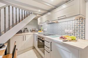 une cuisine avec des placards blancs et un escalier dans l'établissement 2 Bed in Advent oc-p6188, à Camelford 17 autres photos