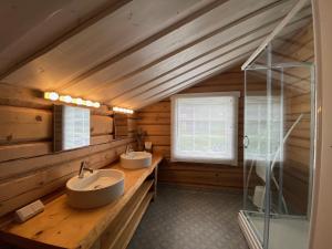 a bathroom with two sinks and a glass shower at The Moose Lodge Swedish Nature Retreat in Bräcke