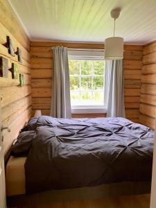 a bedroom with a bed and a window at The Moose Lodge Swedish Nature Retreat in Bräcke