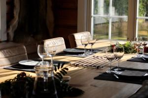 a wooden table with wine glasses on top of it at The Moose Lodge Swedish Nature Retreat in Bräcke +24 photos