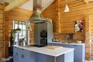 a kitchen with a large island in a wooden kitchen at The Moose Lodge Swedish Nature Retreat in Bräcke